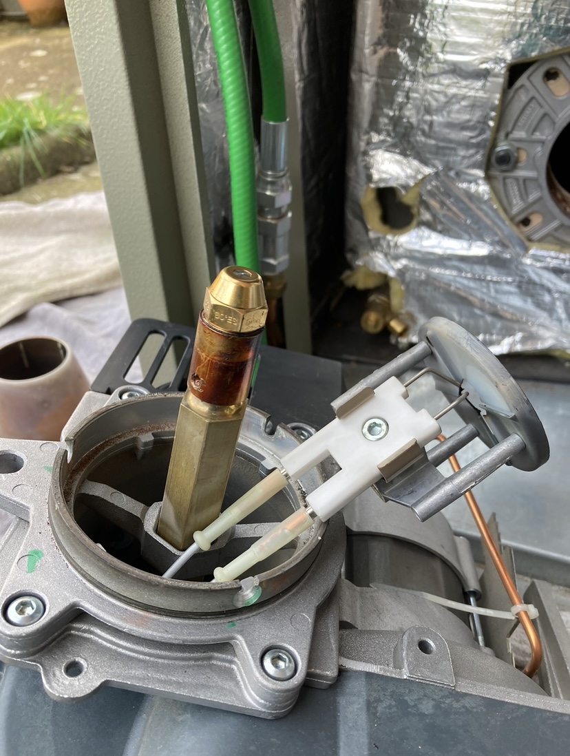 Close-up of an oil burner head and nozzle assembly taken out for a service